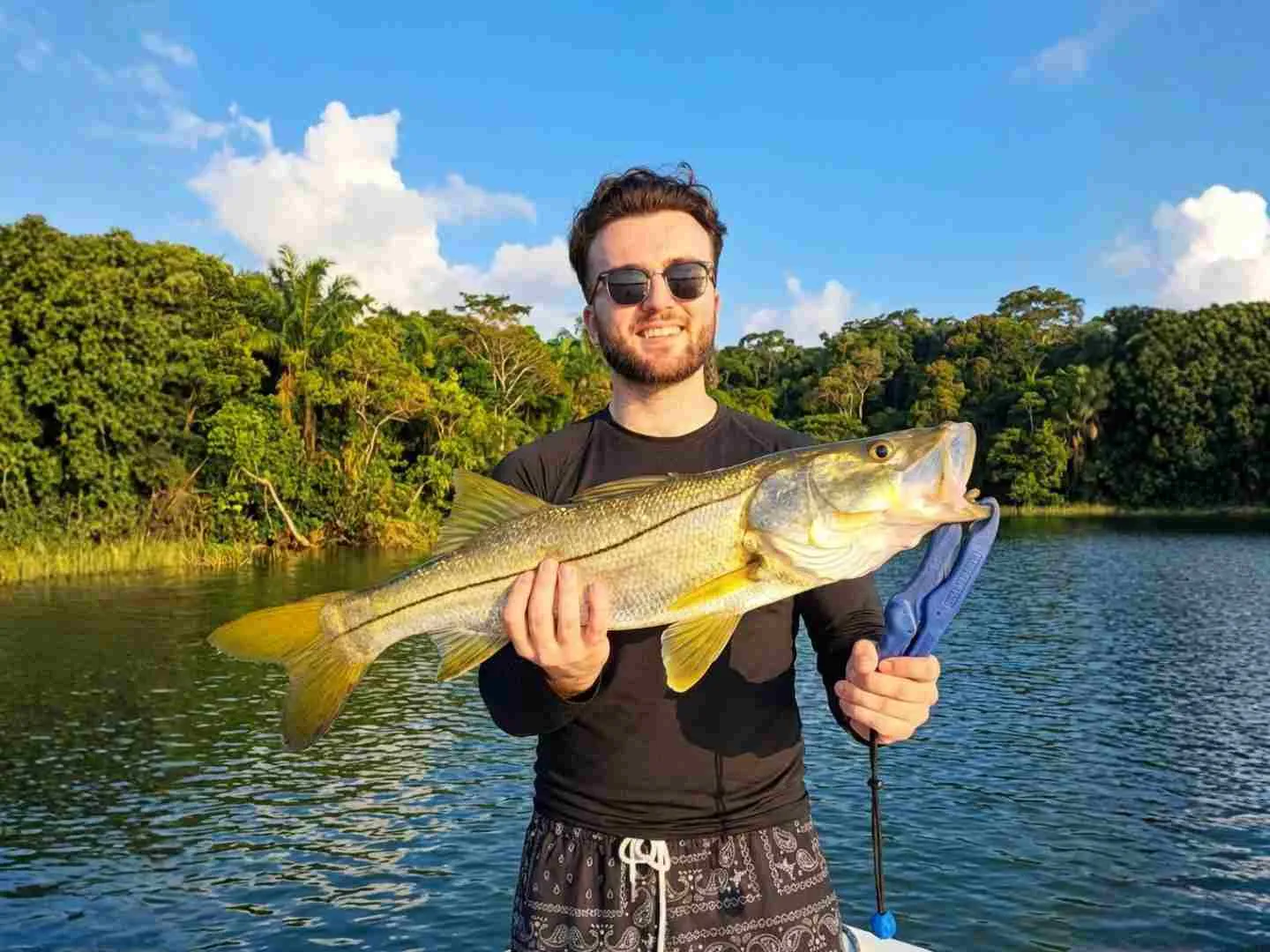 Angler holding a large snook caught on Lake Gatun